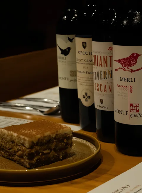Tiramisú junto a cuatro botellas de vino toscano de la carta: I Merli y dos Chianti de Cecchi